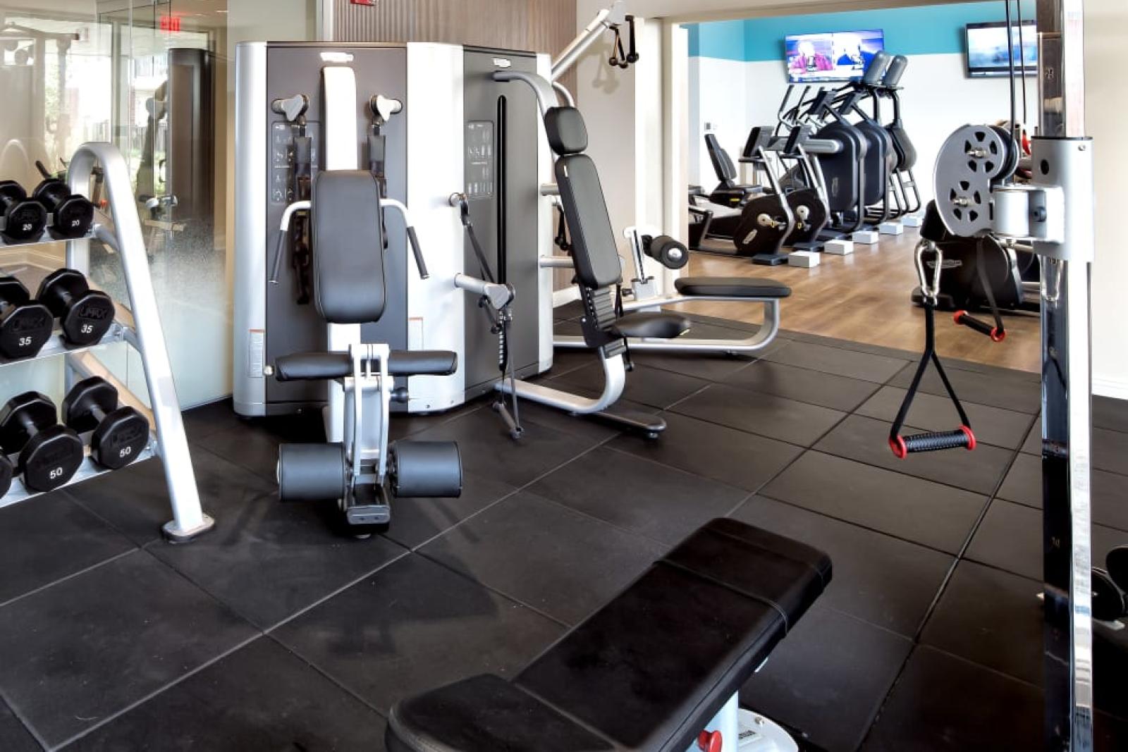 A fully equipped gym featuring weight machines, free weights, and cardio equipment, offering residents a high-end workout experience.