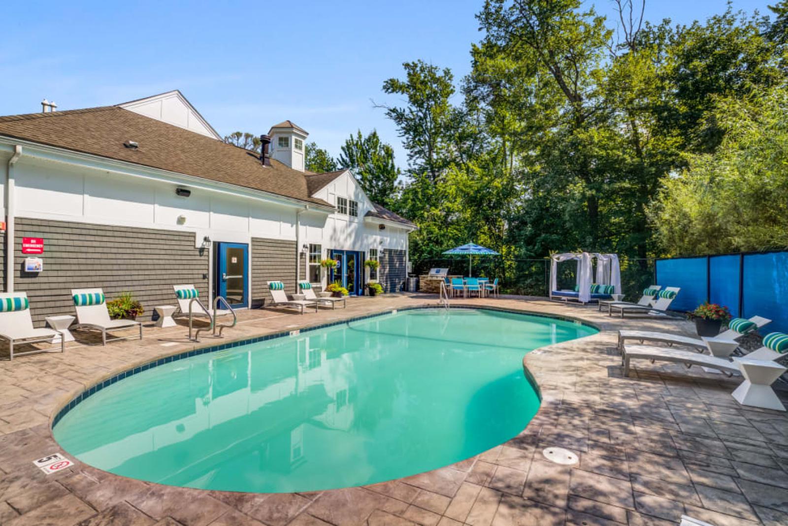 The luxurious pool area at Oak Enclave Luxury Apartments offers a sparkling resort-style pool, comfortable lounge seating, and shaded cabanas for ultimate relaxation.