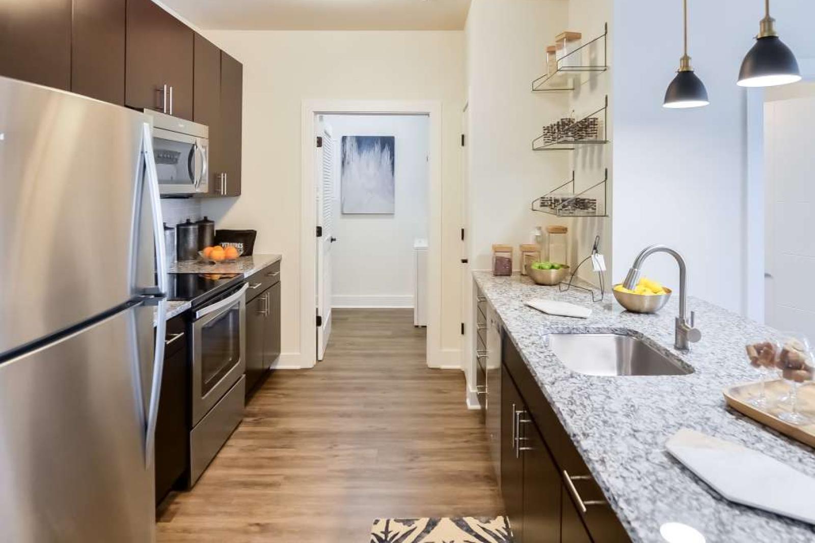 Sleek galley-style kitchen with stainless steel appliances, granite countertops, and thoughtful storage solutions, perfect for modern living.