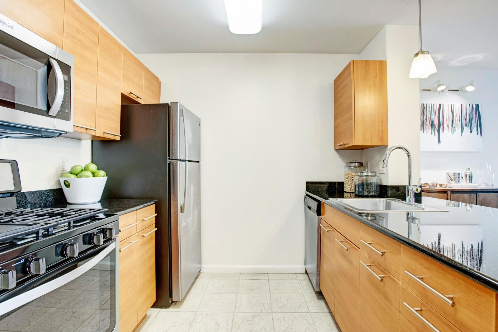 A sleek kitchen with stainless steel appliances, wooden cabinetry, and a spacious island counter perfect for meal preparation or casual dining.