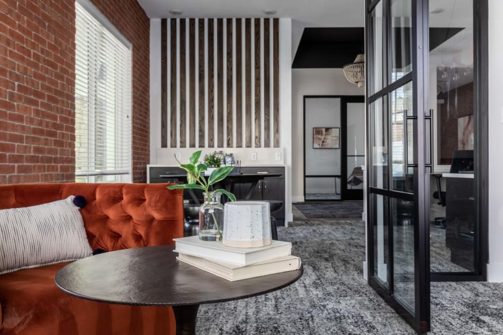 Intimate seating area featuring a vibrant orange sofa, modern decor, and a cozy atmosphere perfect for relaxation or meetings.