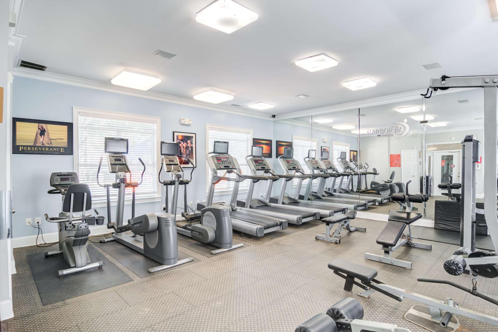 On-site fitness center featuring treadmills, ellipticals, strength machines, and mirrors.