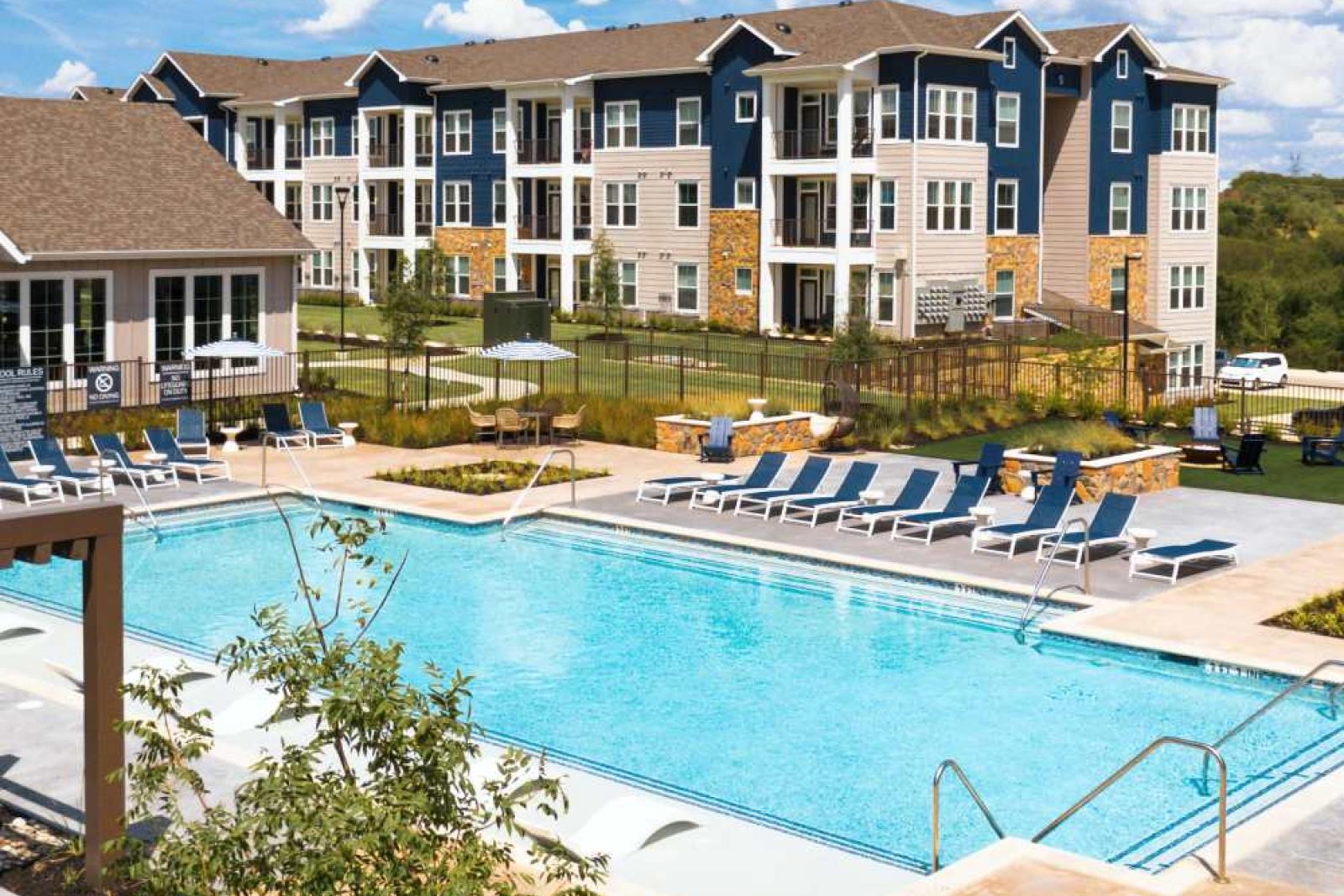 A spacious outdoor fitness area with high ceilings, functional training equipment, and natural lighting.