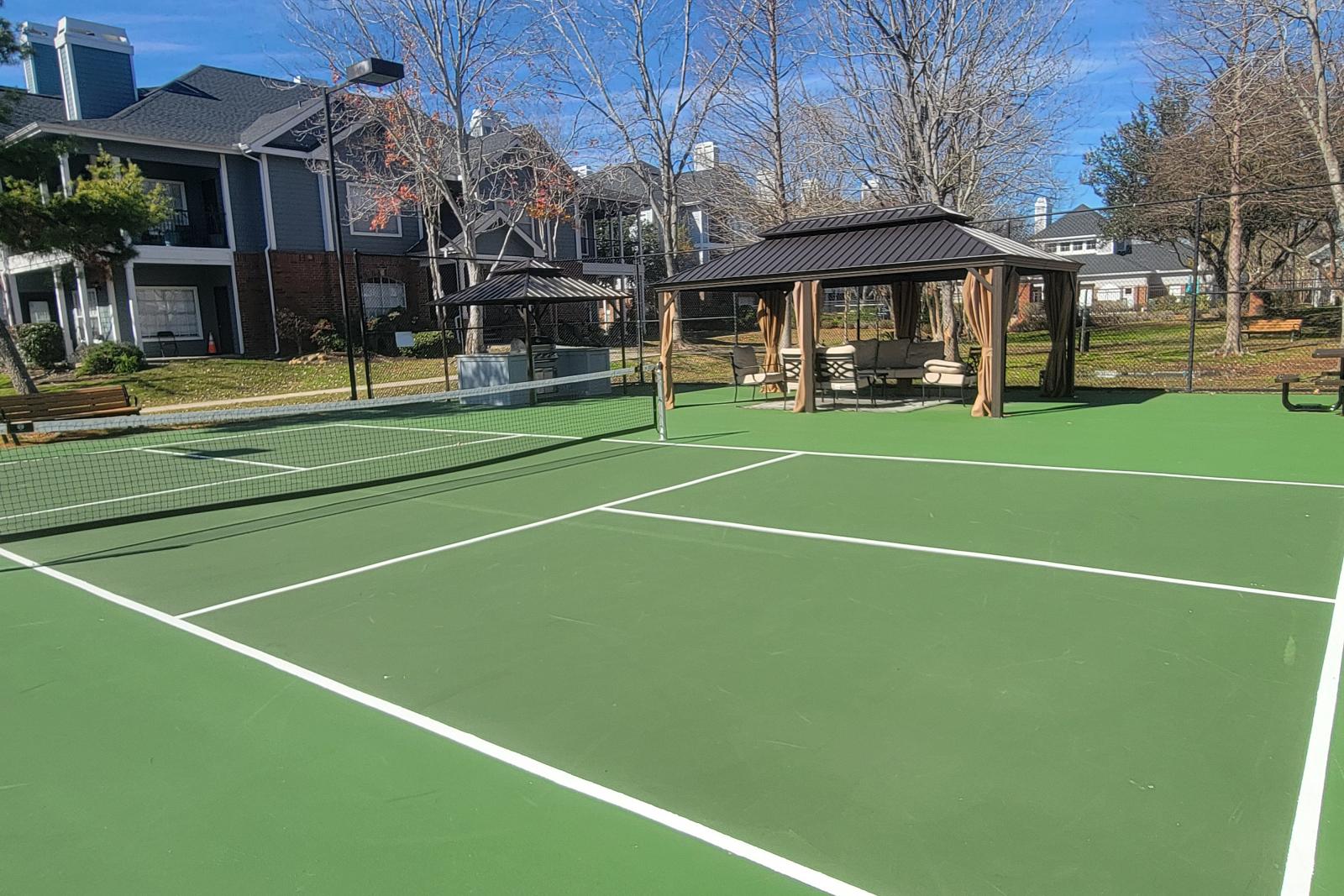 Outdoor tennis and pickleball court with shaded seating pavilion at Gates at Citiplace community