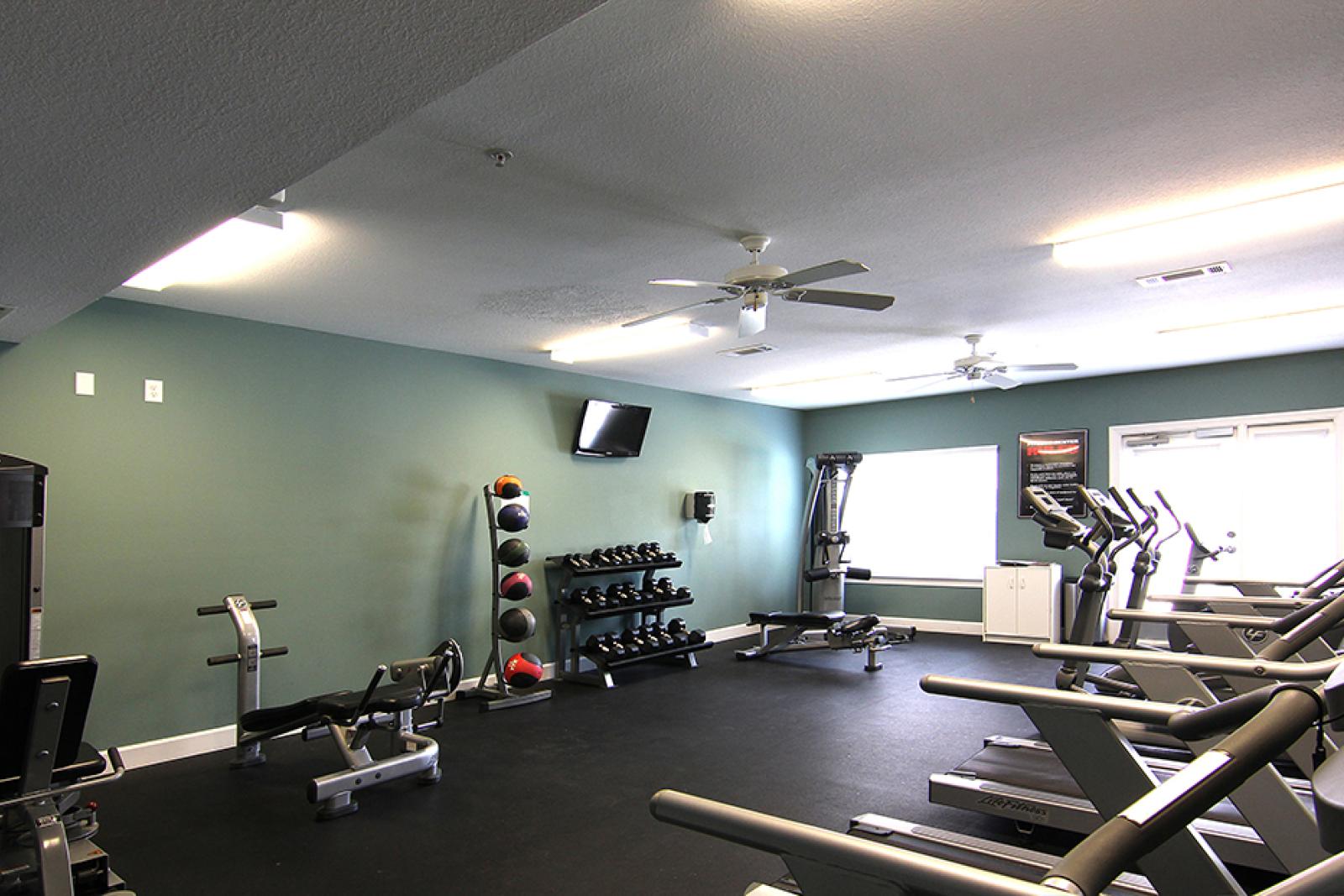 Fitness center with cardio machines and free weights at Reed Creek Apartments, offering residents a modern gym experience.