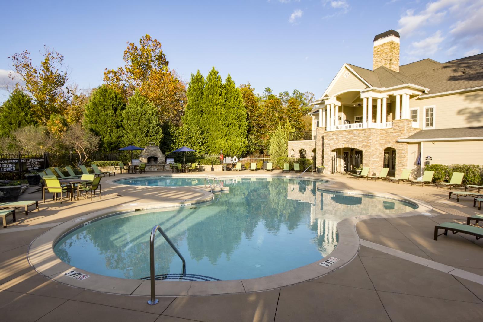Spacious pool area at The Heights at Lake Murray with elegant clubhouse and cozy poolside loungers