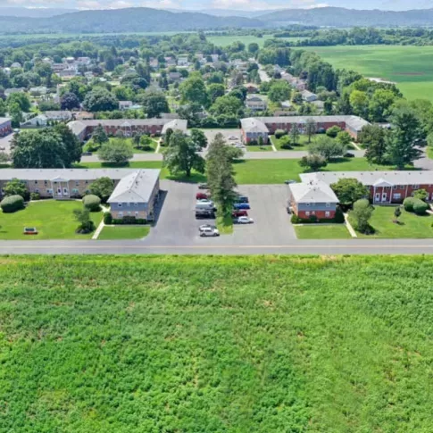 Aerial view showcasing the neat layout of residential units, courtyards, and surrounding fields.