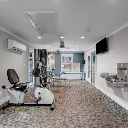 Another angle of the fitness center showing additional machines and a hydration station.
