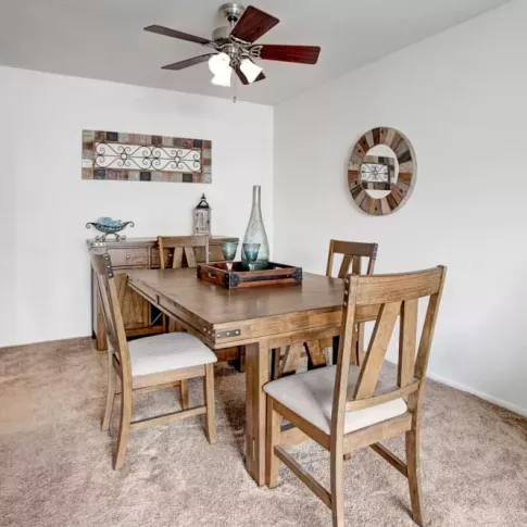 A cozy dining room with a rustic wooden table, chairs, and tasteful wall decor.
