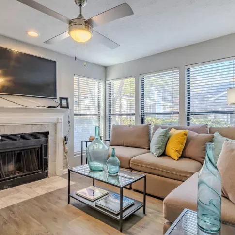 A cozy living room with a tiled fireplace, wall-mounted TV, and contemporary decor accents.