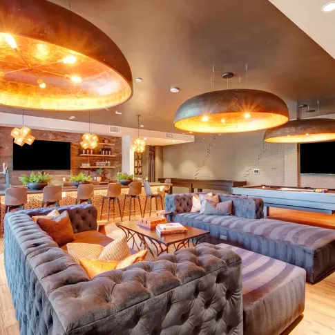 Elegant community space with a sleek bar setup, pendant lighting, and upscale décor for social gatherings and relaxation.