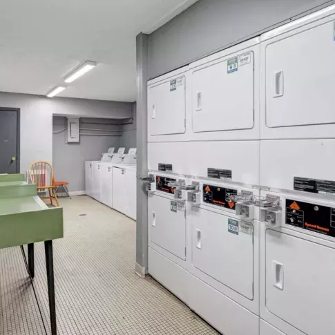 Well-maintained laundry room with washing machines, dryers, and folding stations for resident convenience.