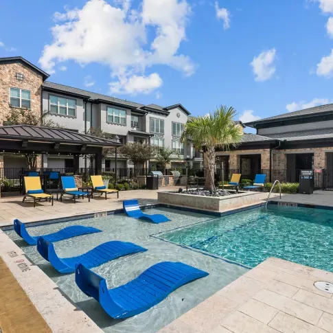 A luxurious poolside with chaise loungers, cabanas, and vibrant landscaping, perfect for relaxation.