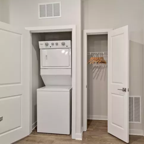 Walk-in closet with white shelving, neatly folded towels, and ample space for hanging clothes and storage.