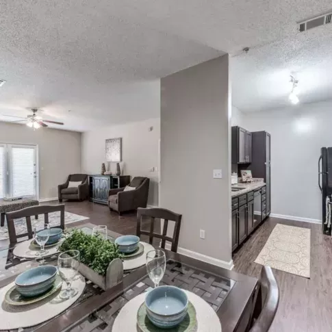 Spacious dining and living area with stylish decor, featuring a set dining table and comfortable seating.