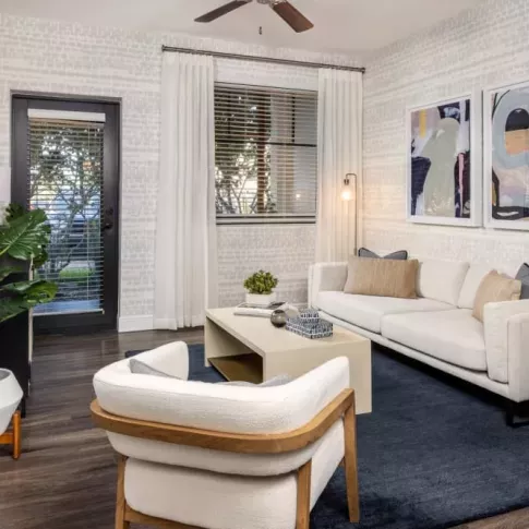 A spacious layout with a cozy seating area, sleek shelving, and a gourmet kitchen with stainless steel appliances and an island for casual dining.