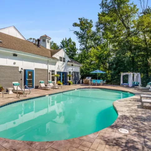 The luxurious pool area at Oak Enclave Luxury Apartments offers a sparkling resort-style pool, comfortable lounge seating, and shaded cabanas for ultimate relaxation.