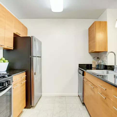 A sleek kitchen with stainless steel appliances, wooden cabinetry, and a spacious island counter perfect for meal preparation or casual dining.