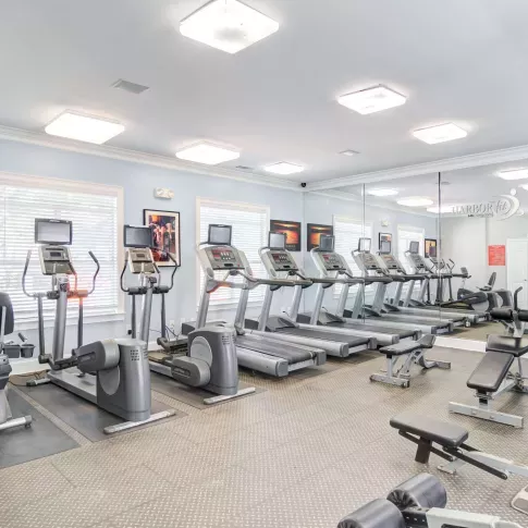 On-site fitness center featuring treadmills, ellipticals, strength machines, and mirrors.