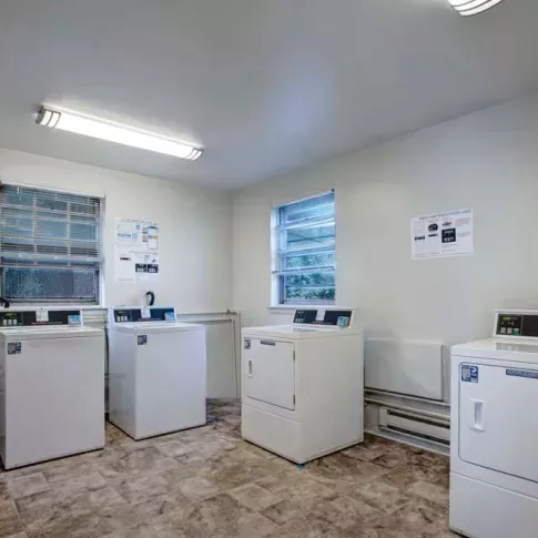 A clean and well-maintained laundry room equipped with multiple washers and dryers, ensuring hassle-free laundry days for residents.