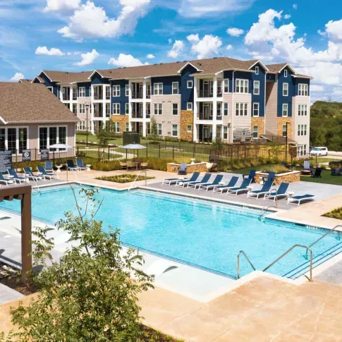 A spacious outdoor fitness area with high ceilings, functional training equipment, and natural lighting.