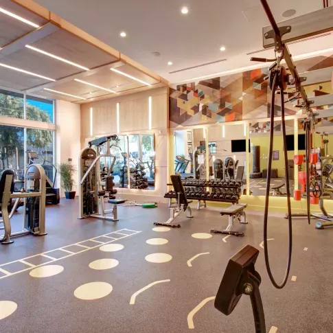 Fully equipped fitness center with large windows and various workout equipment.