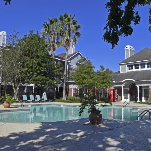 Resort-style swimming pool with lounge chairs and shaded patio seating at Summer Creek Apartments in San Antonio, TX.