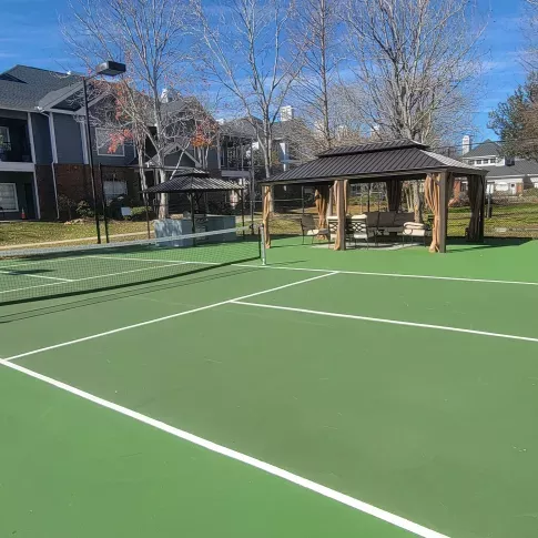 Outdoor tennis and pickleball court with shaded seating pavilion at Gates at Citiplace community