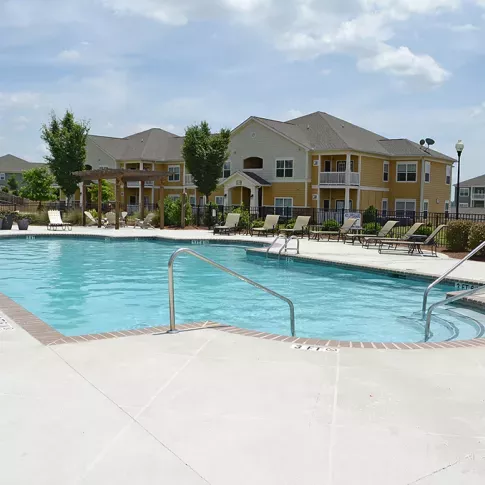 Large outdoor swimming pool with handrails and ample lounge seating at Market Street Station