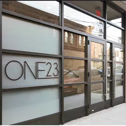 Exterior glass entrance with One23 signage at One23 Apartments in Union City, NJ