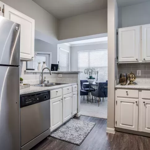Bright kitchen with elegant, white cabinets and stainless steel appliances. 