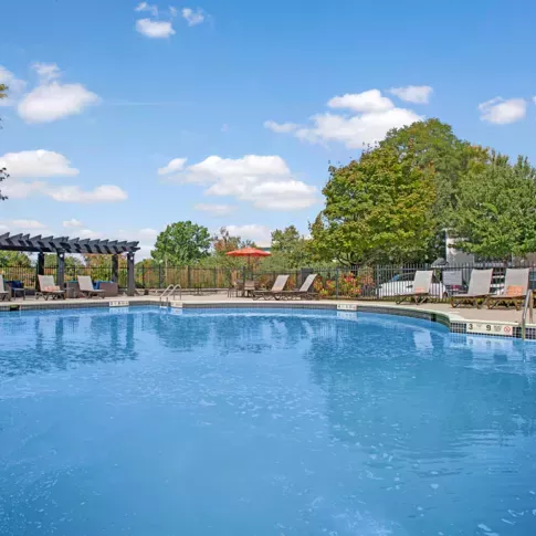 Large, sparkling, resort-style pool with lounge chairs around the perimeter. 
