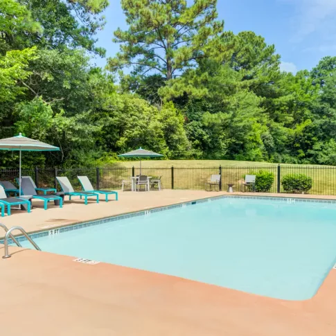 Sparkling, resort style swimming pool with ample seating for residents to enjoy. 