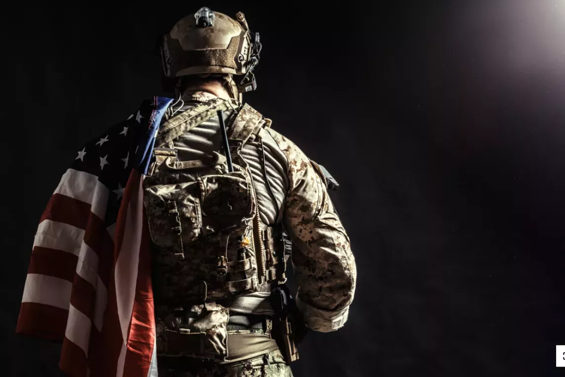 Military person holding American flag