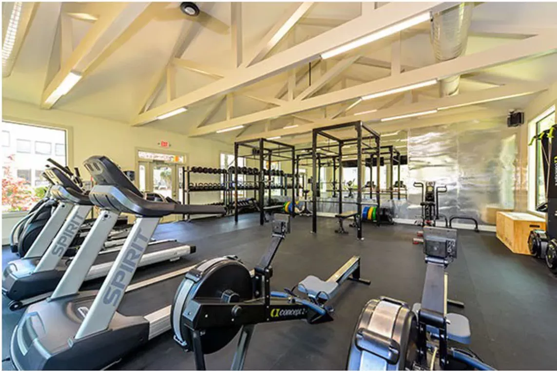 Well-equipped fitness center at Chatsworth Apartments featuring cardio machines, free weights, and a spacious workout area.