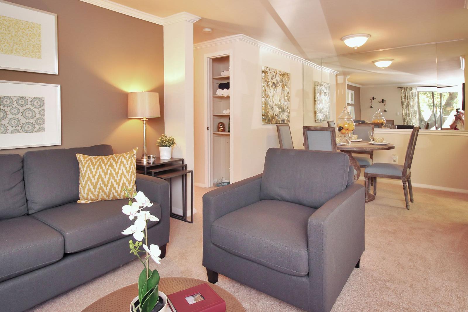 A spacious living room in The Hamptons at Town Center, Germantown, MD, featuring modern furnishings, natural light, and a warm, inviting design.