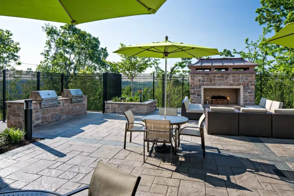Outdoor fireside lounge with seating and BBQ grilling stations, providing a cozy and scenic setting for social gatherings.