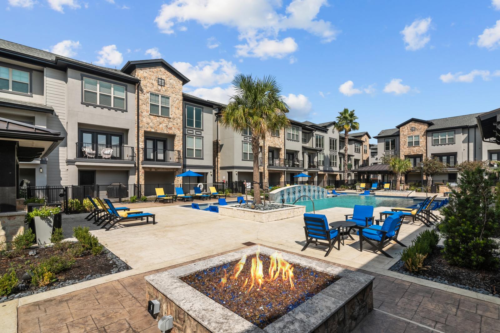 A cozy outdoor fire pit with modern seating, adjacent to the pool area, creating a perfect evening ambiance.