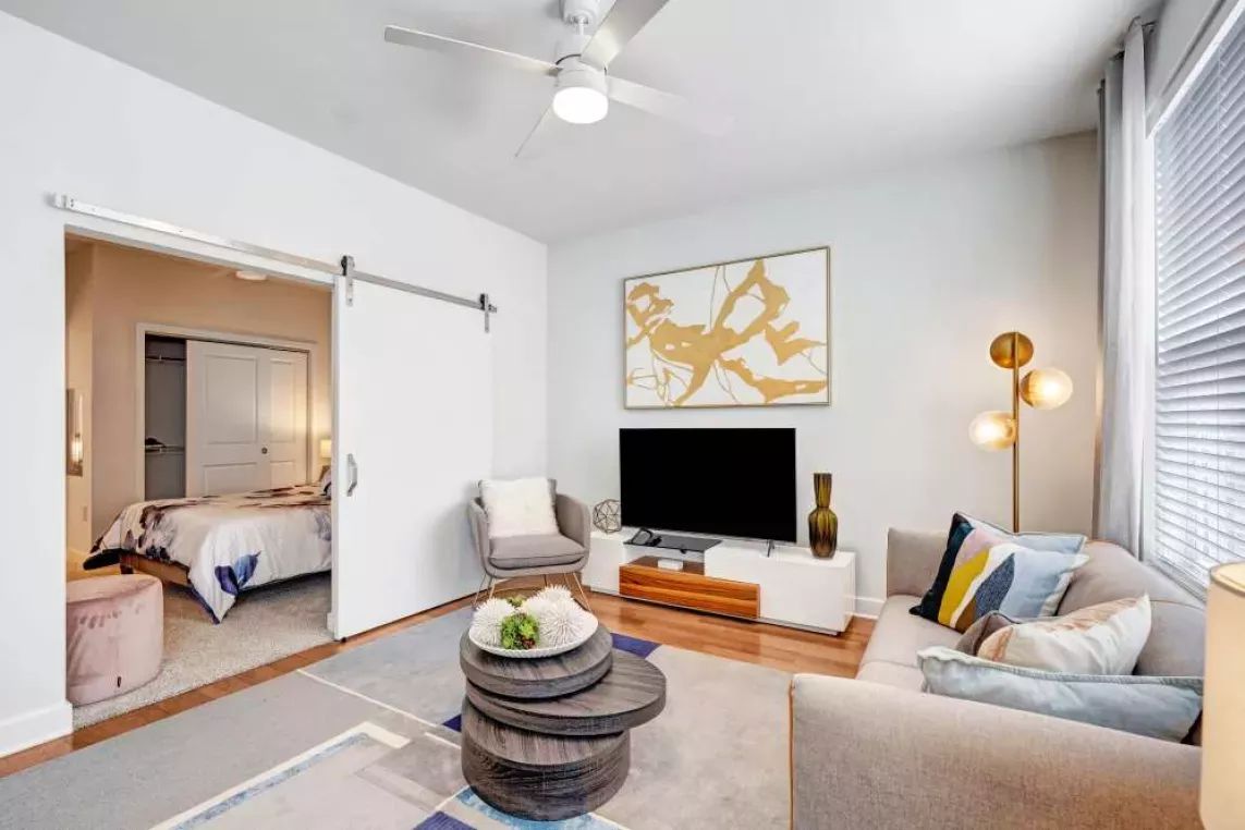 A contemporary living room featuring a stylish TV console, plush seating, and a decorative gold-accented artwork for an elegant touch.