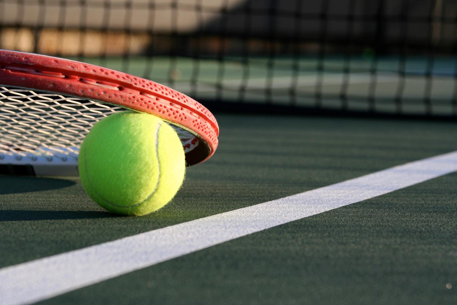 Tennis ball and racquet on the court