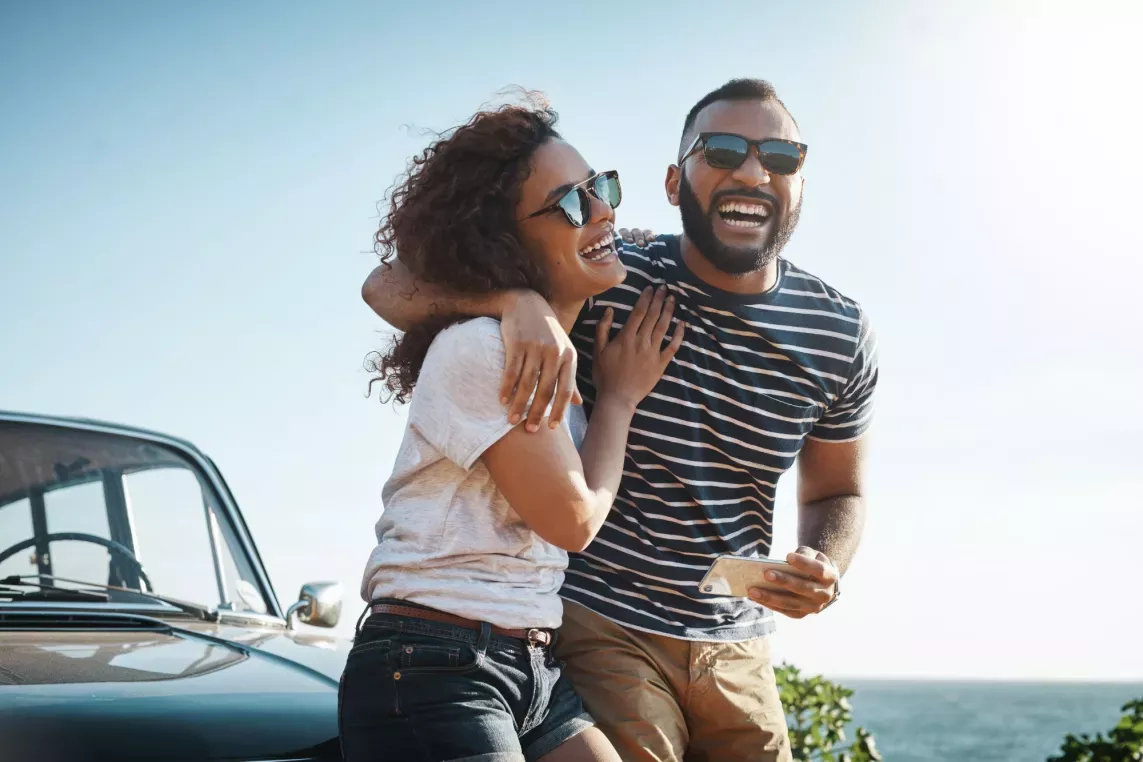 A couple laughing near the ocean