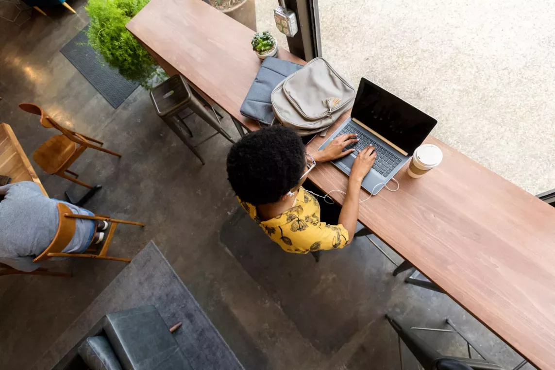 Birds eye view of a students typing on their laptop