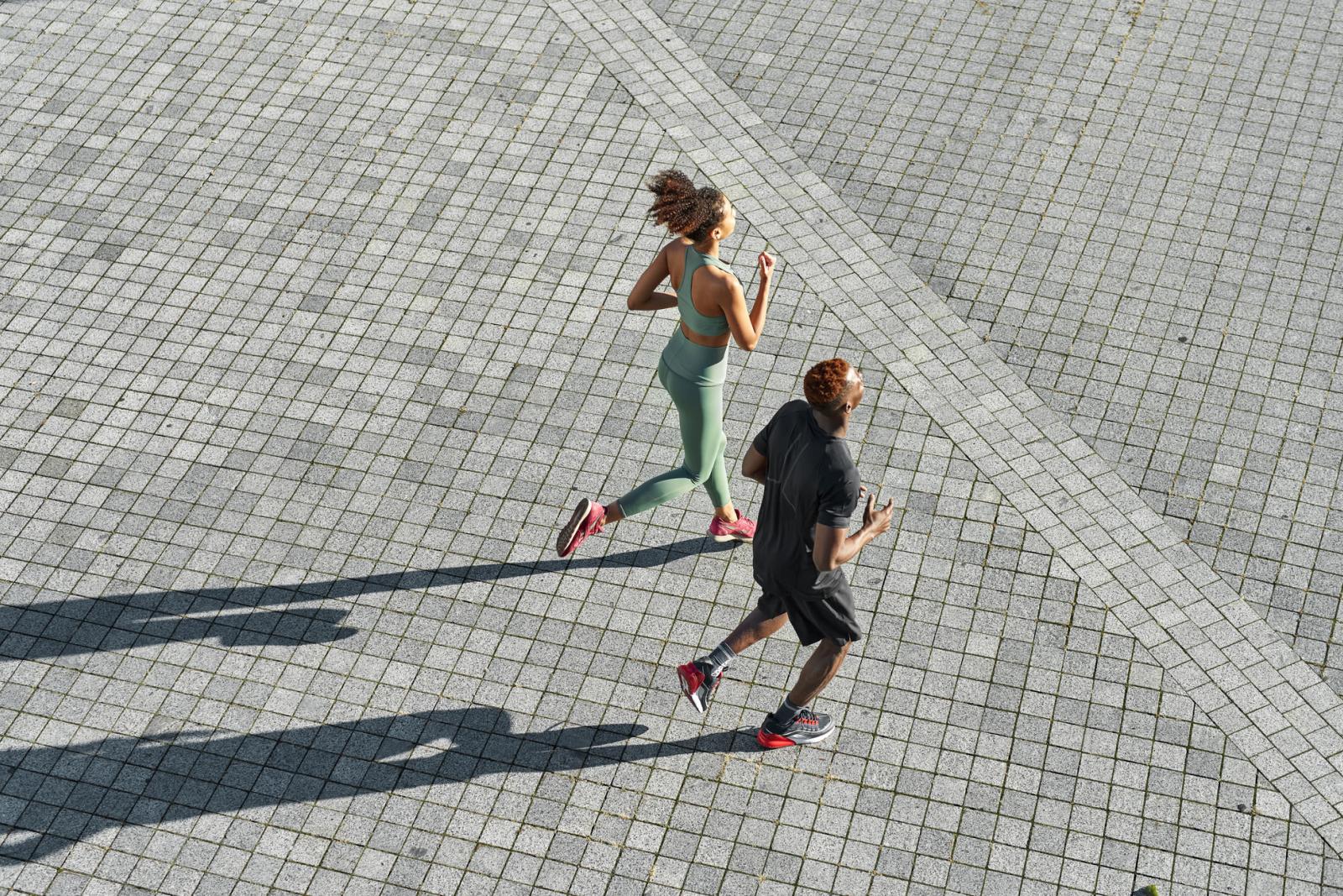 Two people running on pavement