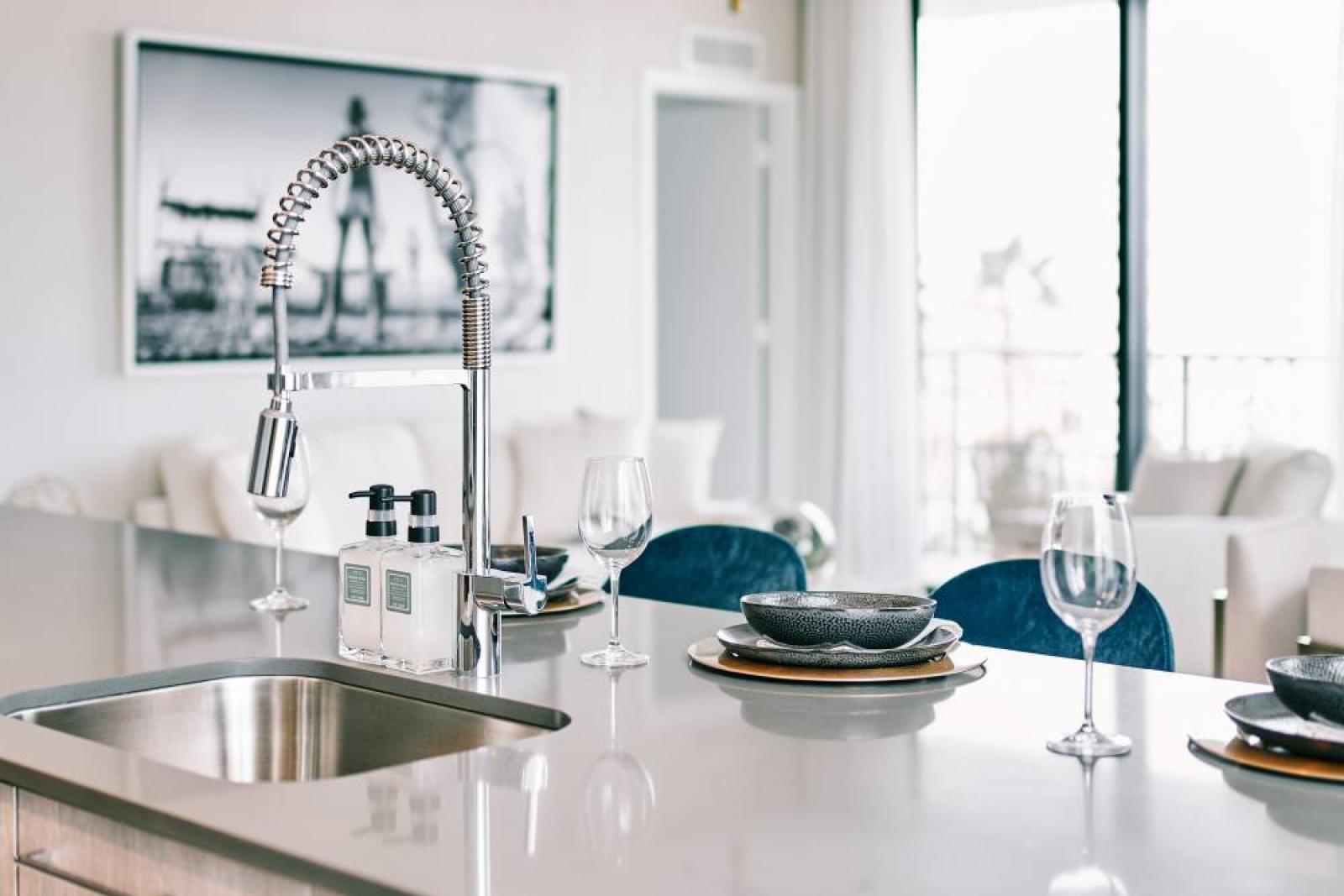 Contemporary kitchen at Parkline Miami featuring quartz countertops, stainless steel appliances, and floor-to-ceiling windows with city views.