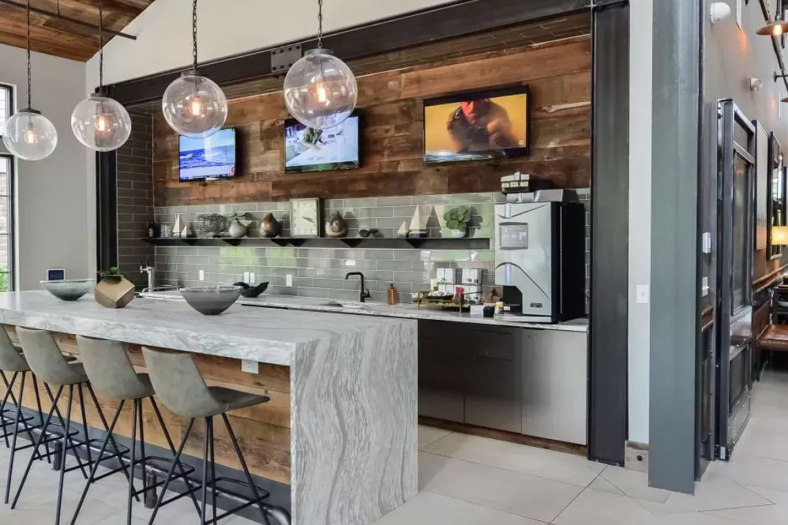 Contemporary coffee bar and kitchen space at Riverworks featuring a modern island with barstool seating.