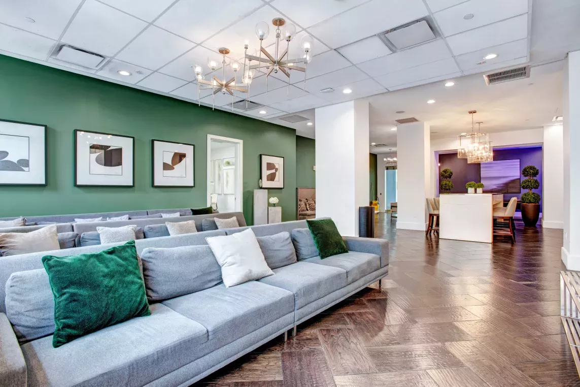Inviting lounge area with plush seating, green accent walls, and stylish decor for relaxation or social gatherings.