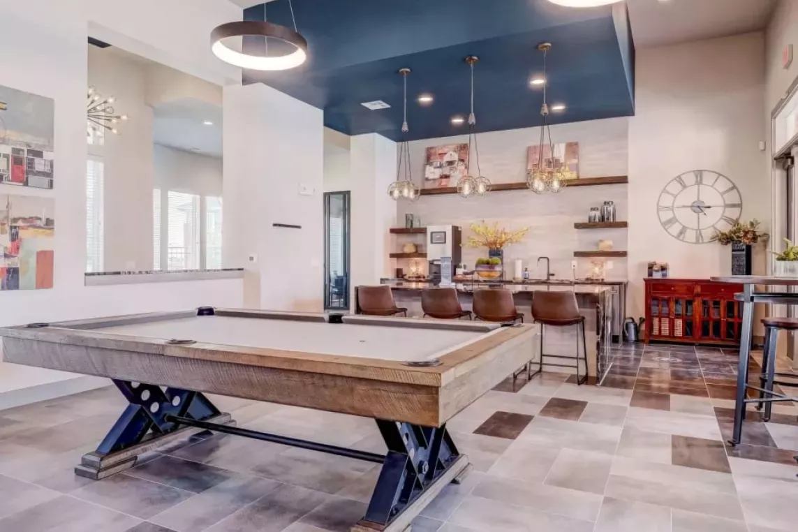 Chic clubhouse featuring a modern pool table, stylish seating, and a spacious entertainment area at The Emerson at Forney Luxury Apartments.