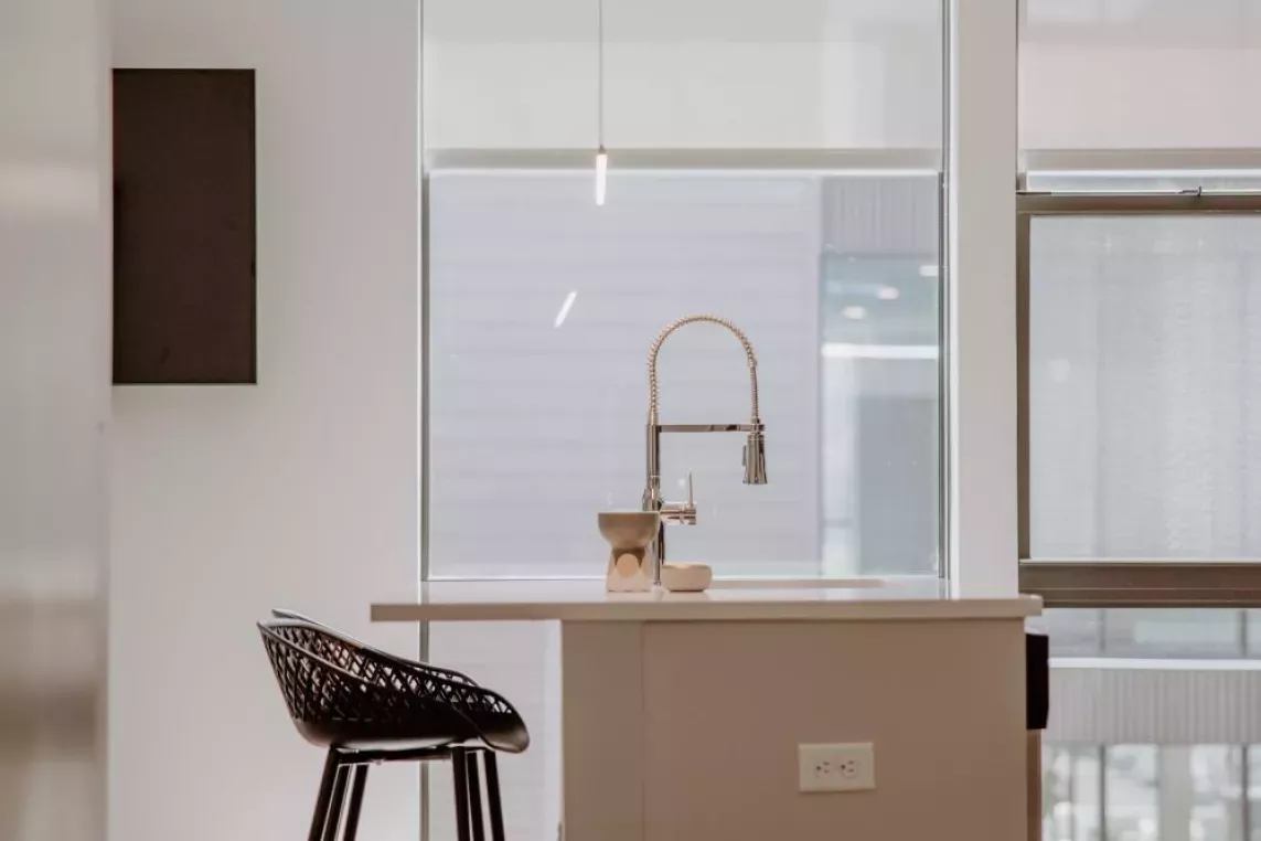 A modern kitchen at Industry Columbus Apartments featuring white cabinetry, stainless steel appliances, and a sleek island with bar seating.