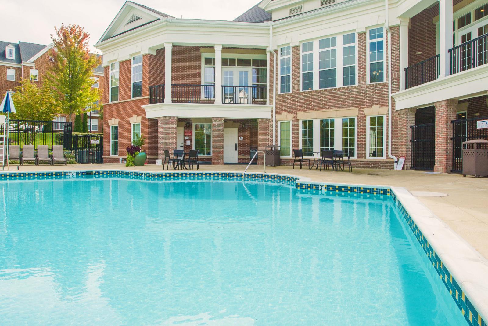 A sparkling swimming pool set against the backdrop of an elegant clubhouse, offering a luxurious and relaxing outdoor space.