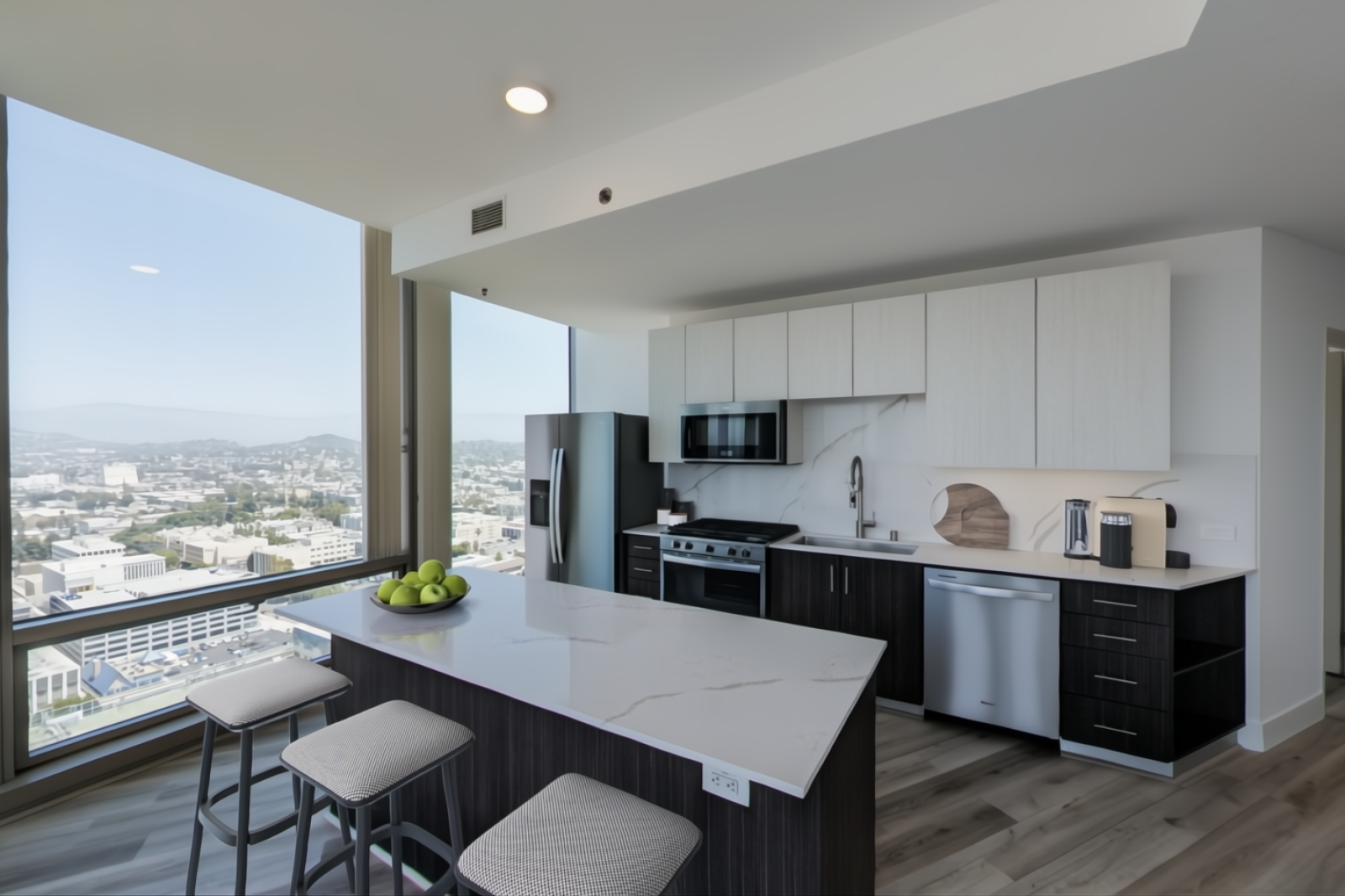 Spacious kitchen and dining area in Nari Koreatown penthouse with barstools at a large quartz island and floor-to-ceiling windows
